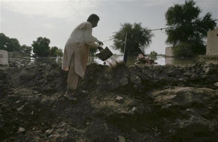 Villager Ghulam Raza works to reinforce the embankment to keep flood waters from entering into Hamdani Legari village near Moro, Pakistan. 